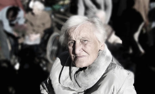 Alte Frau in einer dicken Jacke im Freien